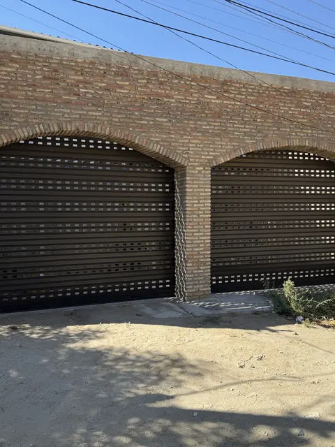 Dos cortinas perforadas en arcos de ladrillo