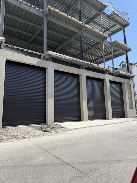 Cuatro cortinas de acero negras en una fila de cocheras